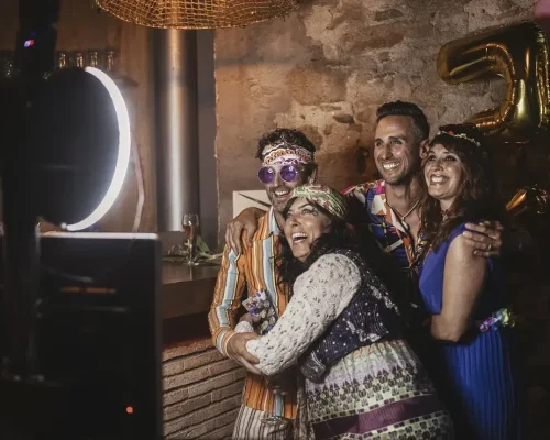 Grupo de amigos posa frente a una maquina de fotos durante un cumpleaños temático | alquiler de fotomaton en Girona